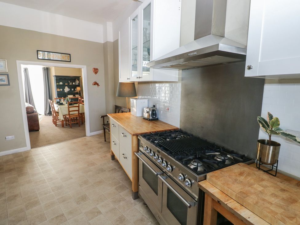 A kitchen with an oven, stove, and wooden counter at Sea Suite