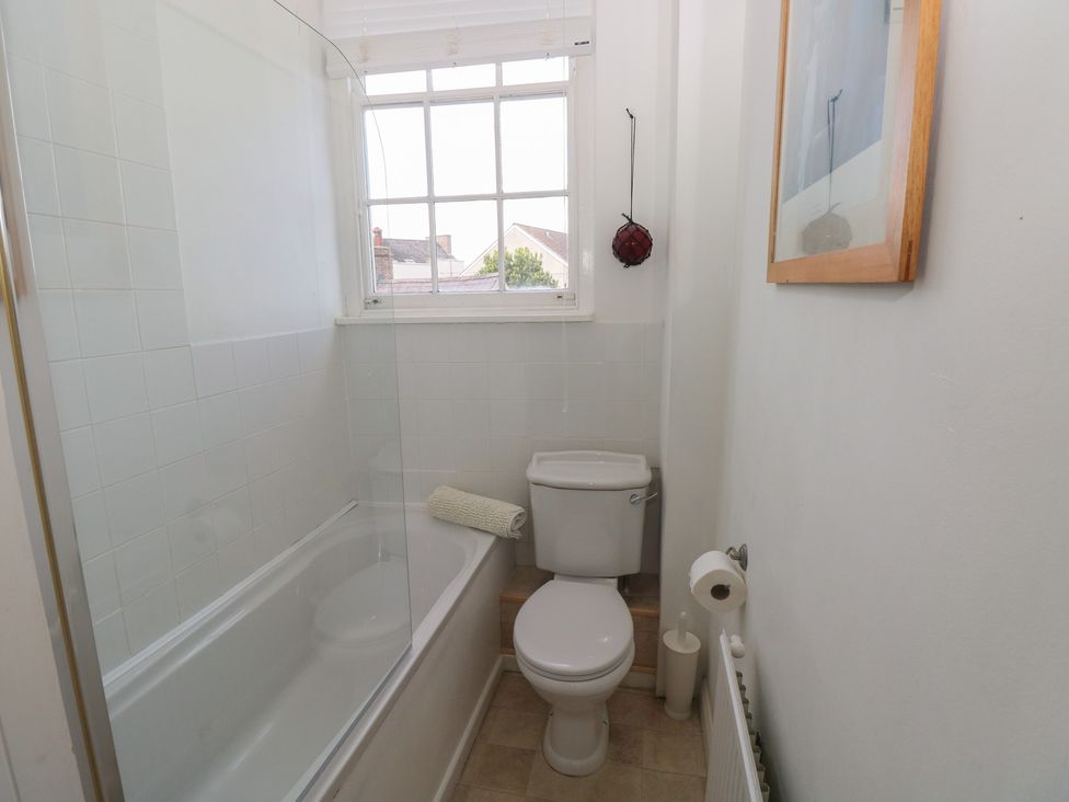 A bathroom with a bath tub and toilet at Sea Suite