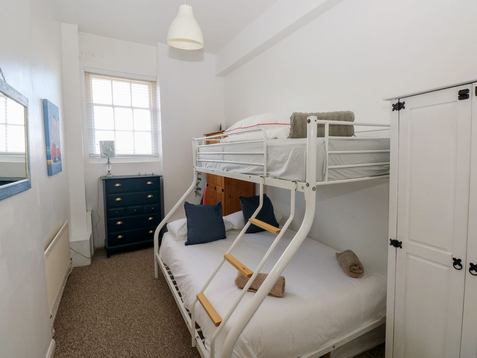 A bedroom with a bunk bed and dresser in Sea Suite