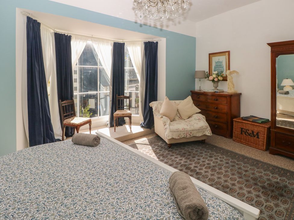 A bedroom with a bed and seating area at Sea Suite