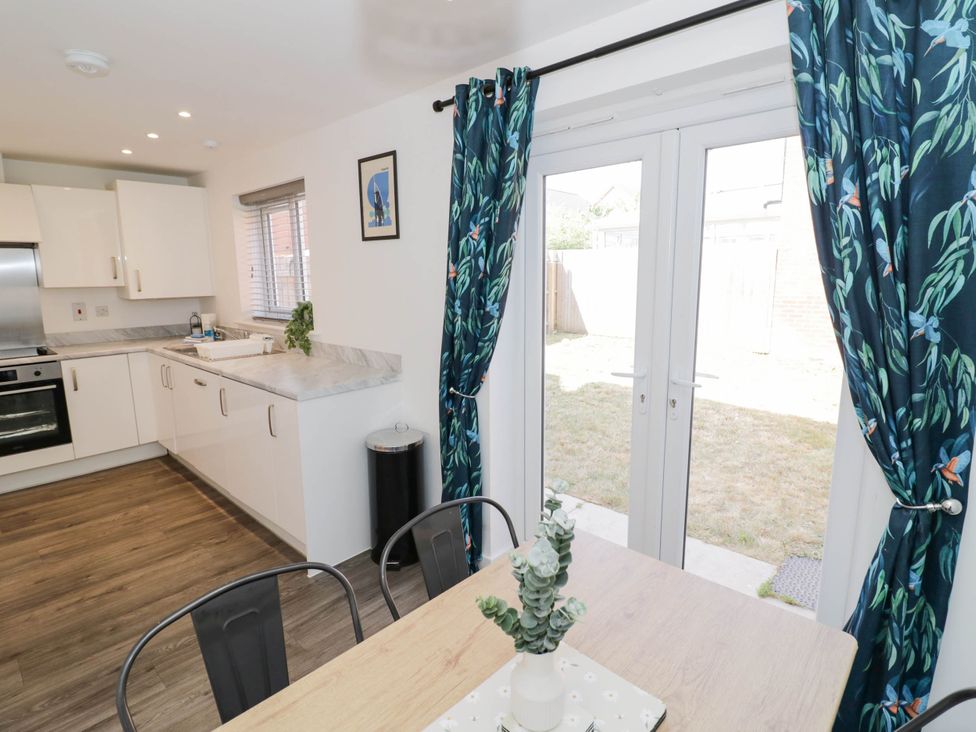 A kitchen with a table and chairs at 5 Warrington Lane in Coventry