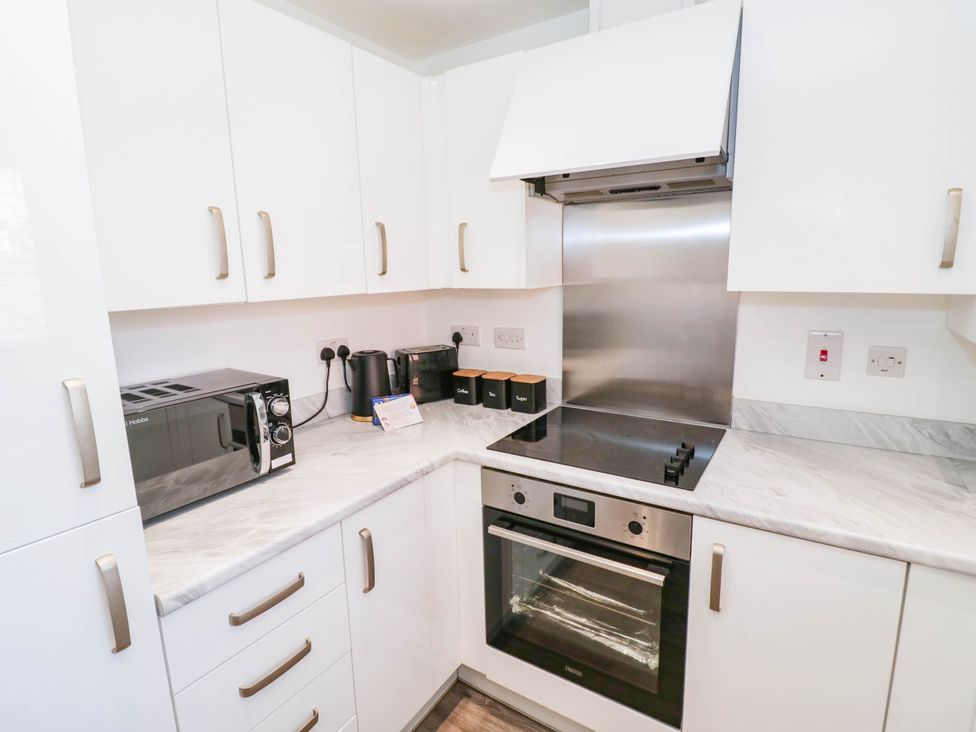 A kitchen with appliances and cabinets at 5 Warrington Lane in Coventry