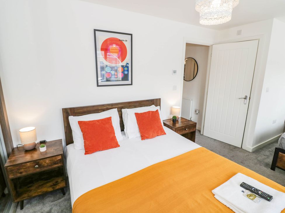 A bedroom with a bed and artwork at 5 Warrington Lane in Coventry