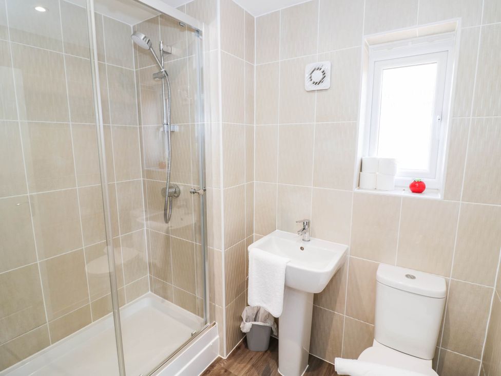 A bathroom with a shower, sink, and toilet at 5 Warrington Lane in Coventry