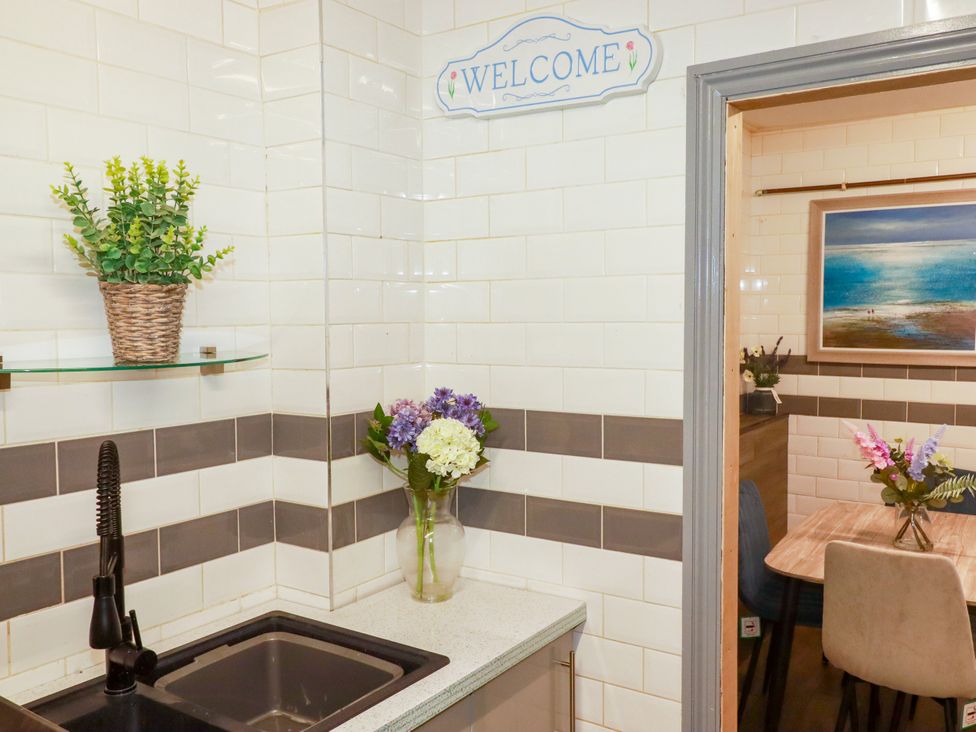 A kitchen with a sink and flowers at Two Bed Apartment No.4 in Newquay