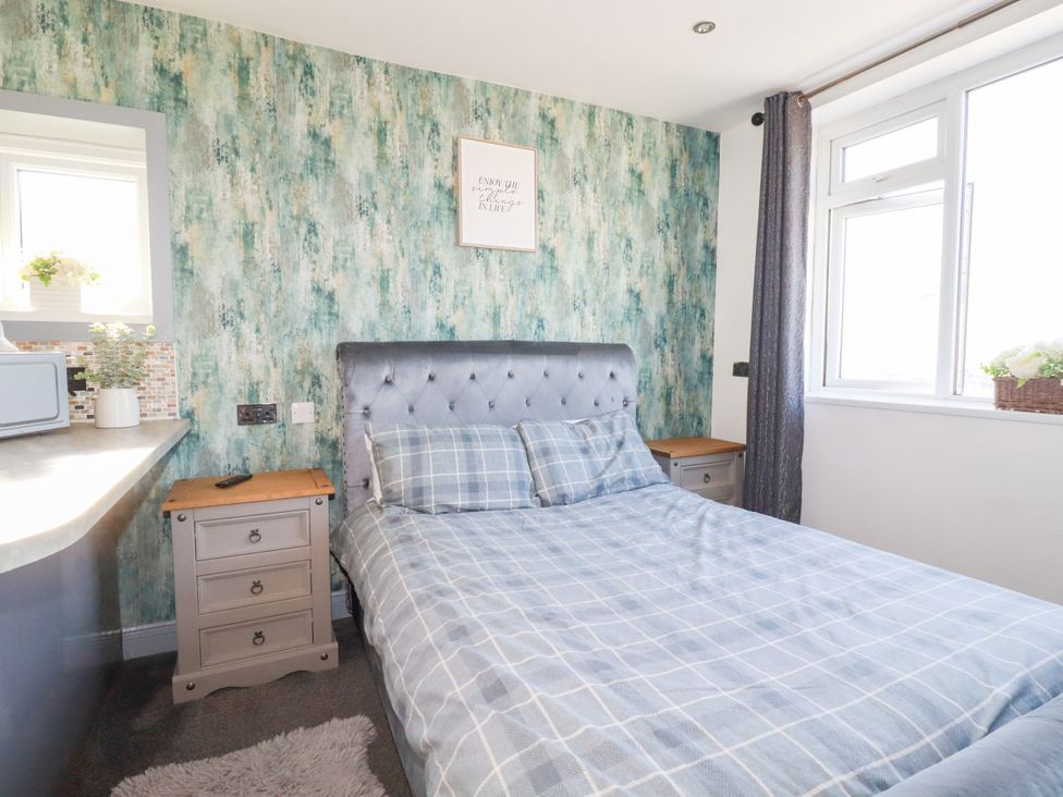 A bedroom with a bed and nightstand at Two Bed Apartment No.4 in Newquay