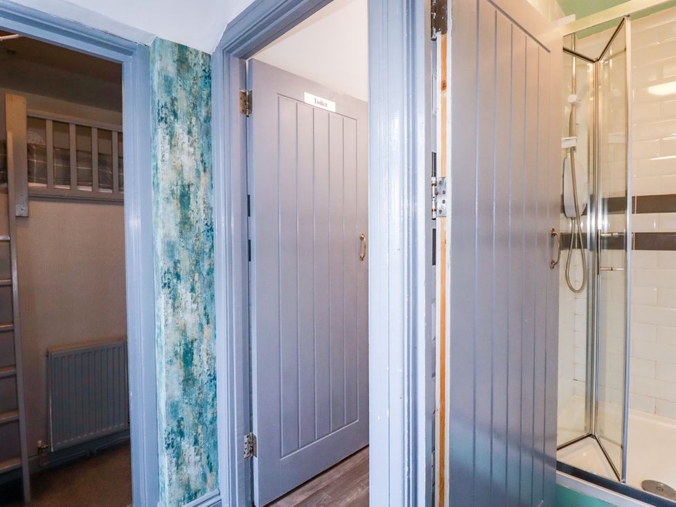 A bathroom with a shower and two doors at Two Bed Apartment No.4 Newquay