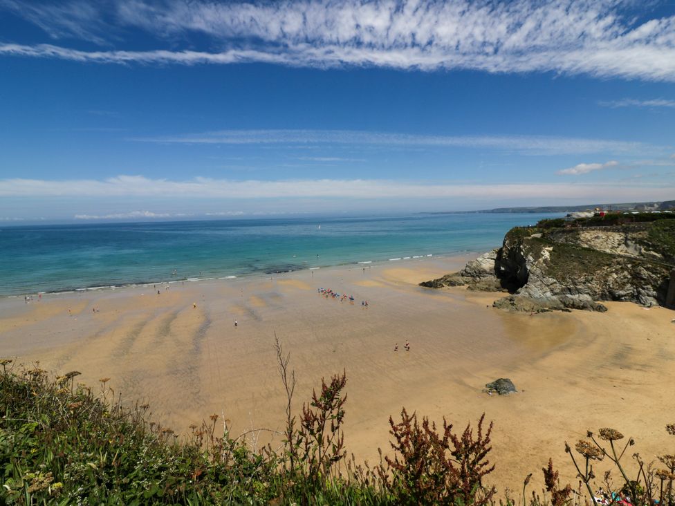 A beach with people and a cliff at Two Bed Apartment No.4 in Newquay