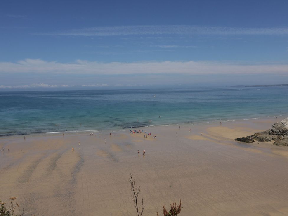 A beach with people walking on sand and water in Penthouse No.3 Newquay