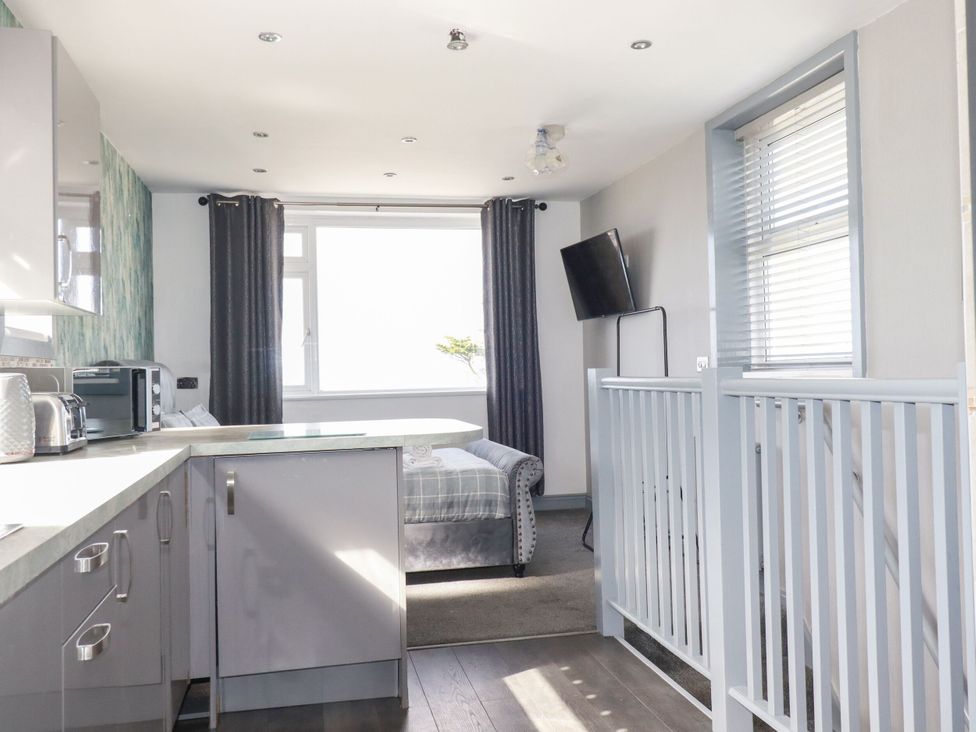 A kitchen with a sofa and television at Penthouse No.3 in Newquay