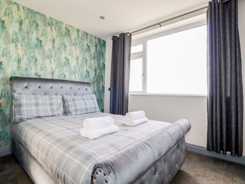 A bedroom with a bed and towels at Penthouse No.3 in Newquay