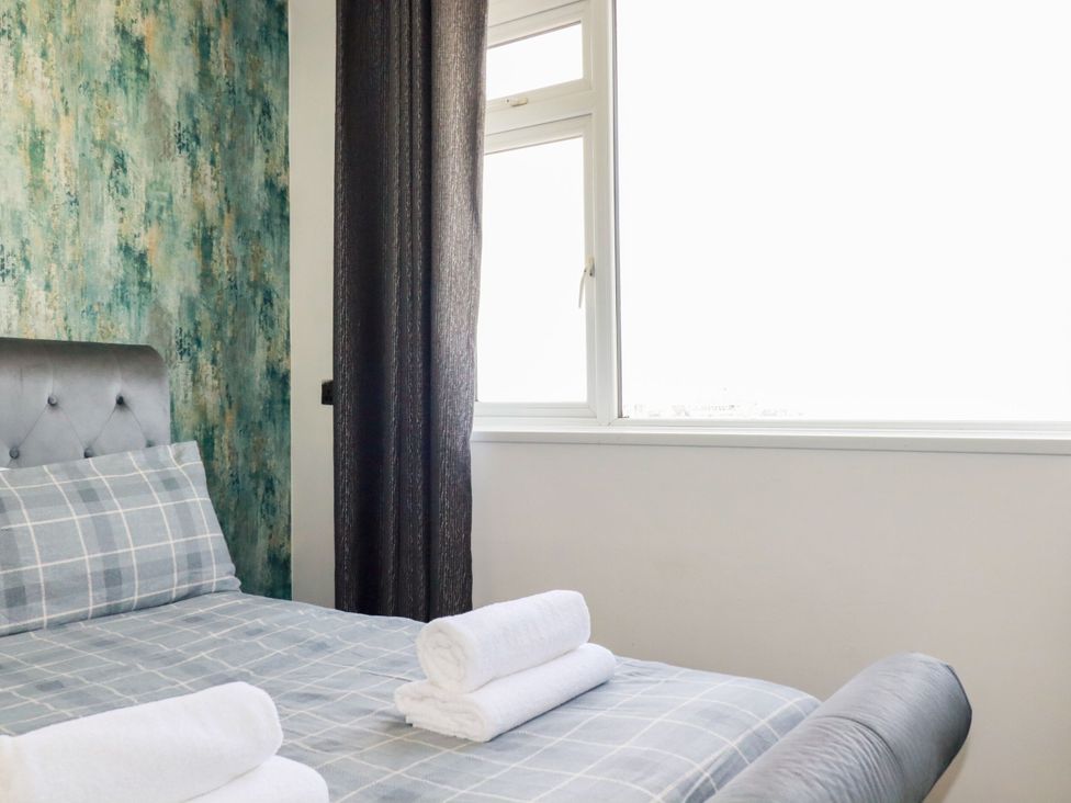 A bedroom with a bed and window at Penthouse No.3 in Newquay