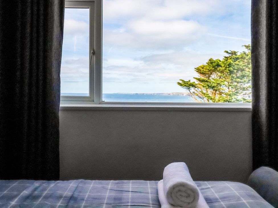 A bedroom with a window showing a sea view at Penthouse No.3 in Newquay