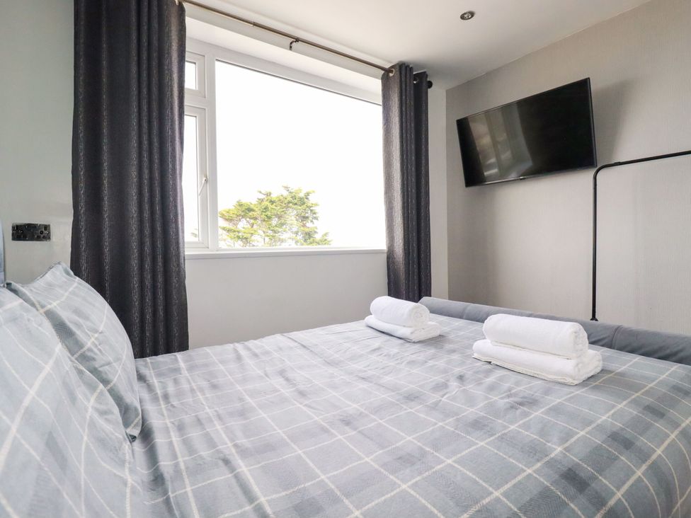 A bedroom with a bed and towels at Penthouse No.3 in Newquay