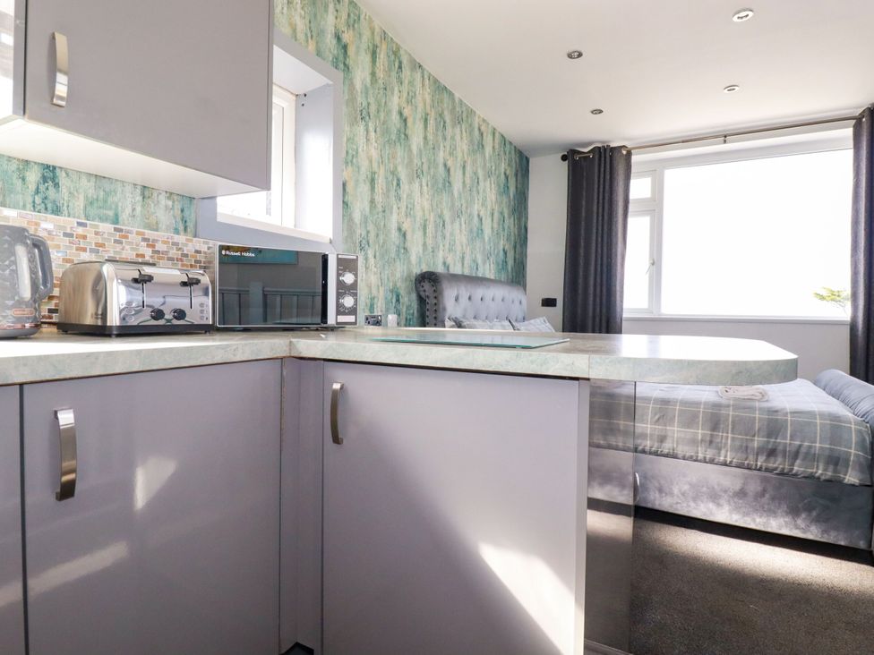 A kitchen with appliances and a bed visible at Penthouse No.3 in Newquay