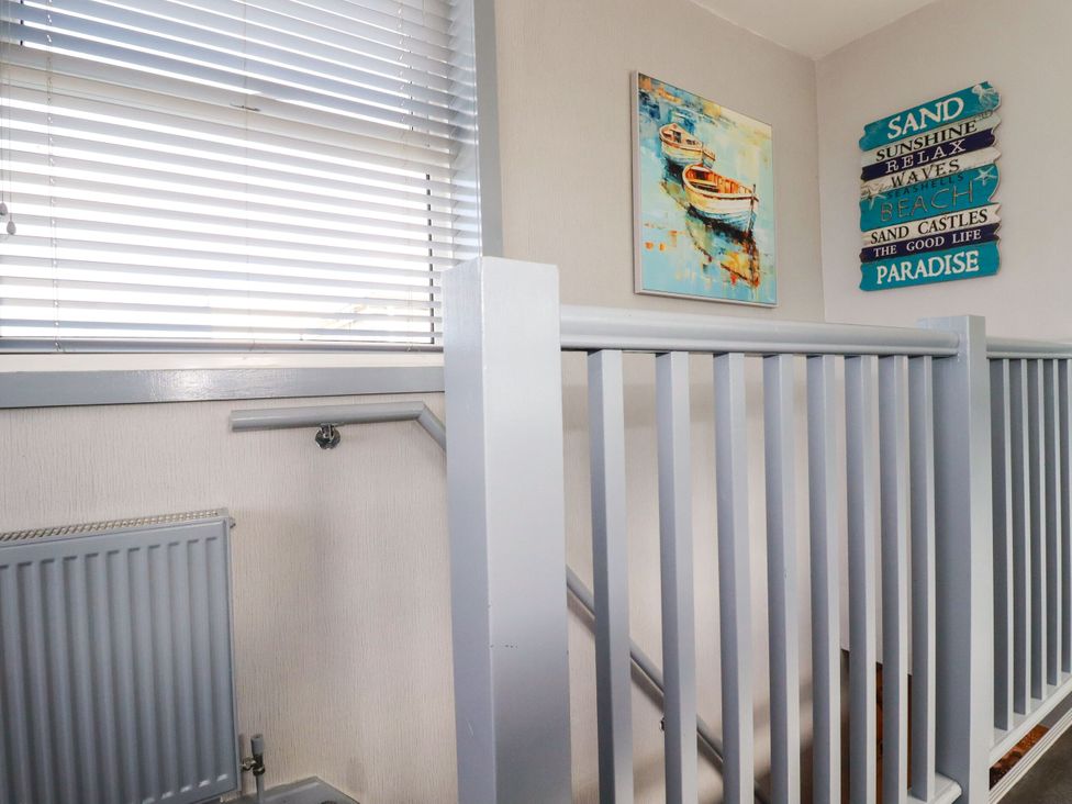 A staircase with railing and wall decor at Penthouse No.3 in Newquay