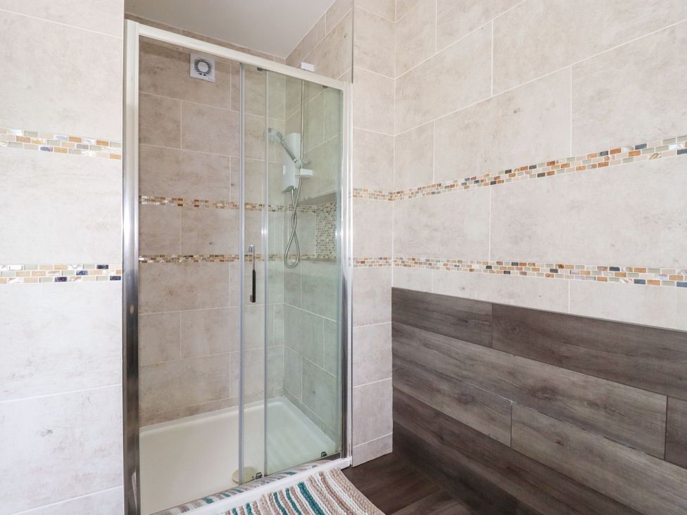 A shower with glass door in a bathroom at Penthouse No.3 in Newquay