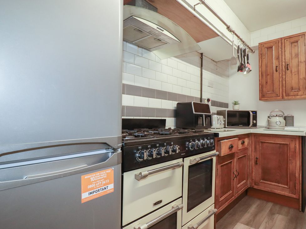 A kitchen with a gas stove, fridge, and countertop at Penthouse No.3 in Newquay