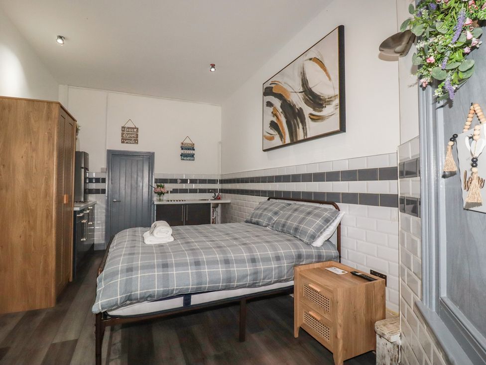 A bedroom with a bed and kitchenette at Penthouse No.3 in Newquay