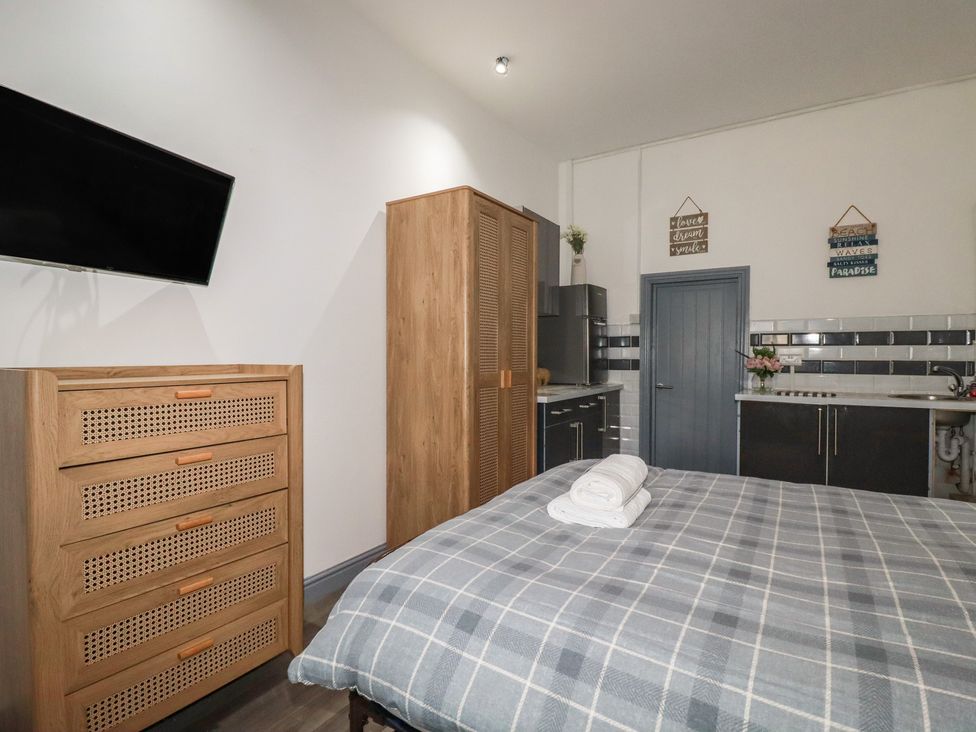 A bedroom with a bed and television at Penthouse No.3 in Newquay