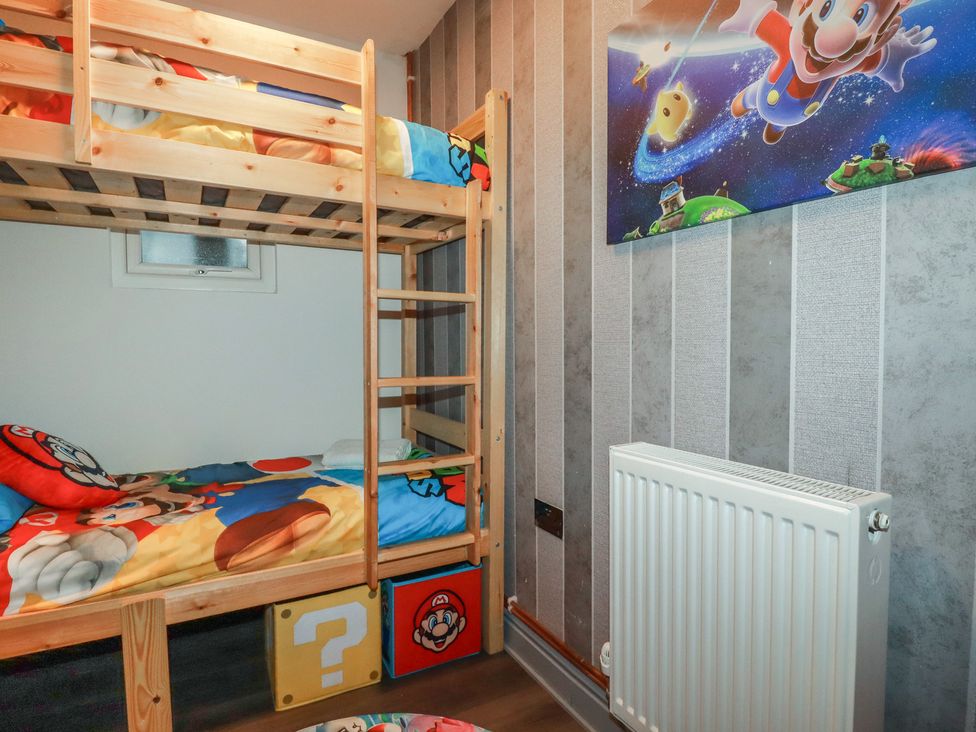 A bedroom with a bunk bed and wall art at Penthouse No.3 in Newquay