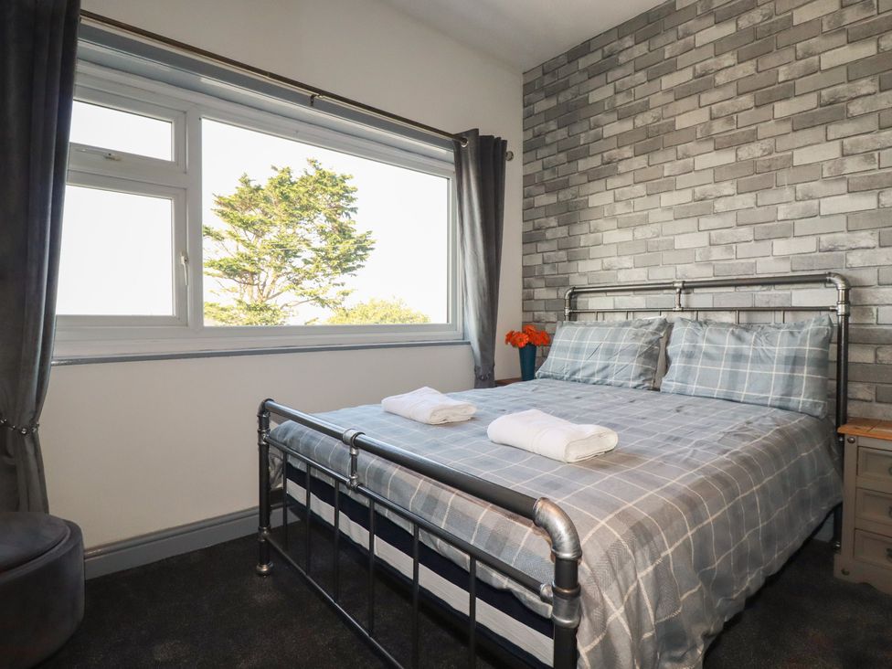 A bedroom with a bed and window at Penthouse No.3 in Newquay