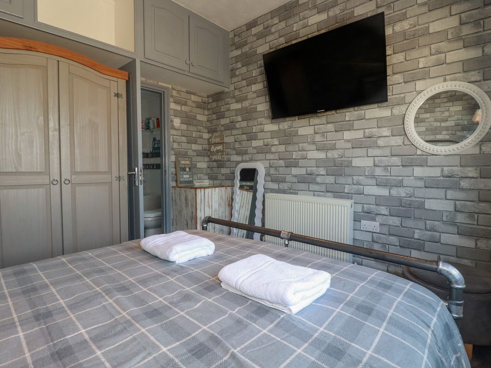 A bedroom with a bed and wardrobe at Penthouse No.3 in Newquay