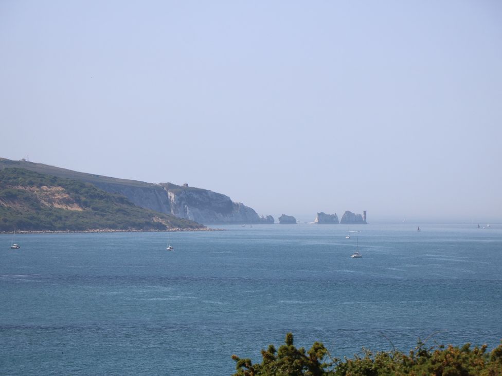A view of the sea with boats and cliffs at 57 Cliff End Freshwater