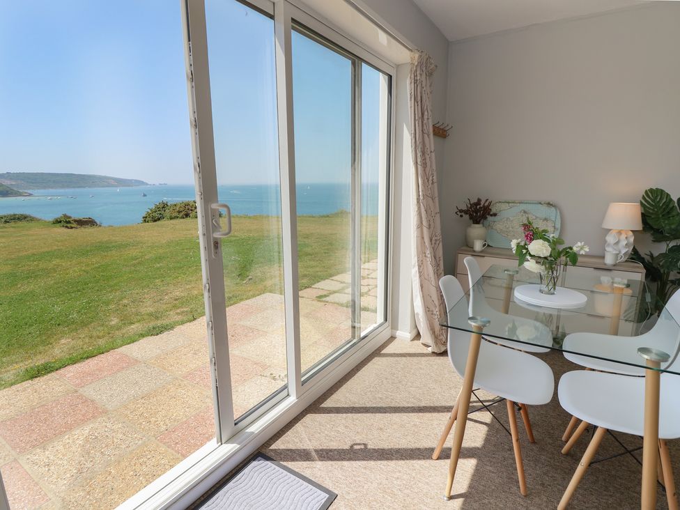 A dining room with a view of the ocean at 57 Cliff End in Freshwater