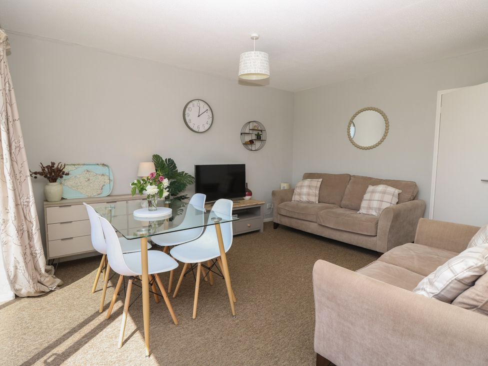 A living room with a dining set and sofa at 57 Cliff End in Freshwater