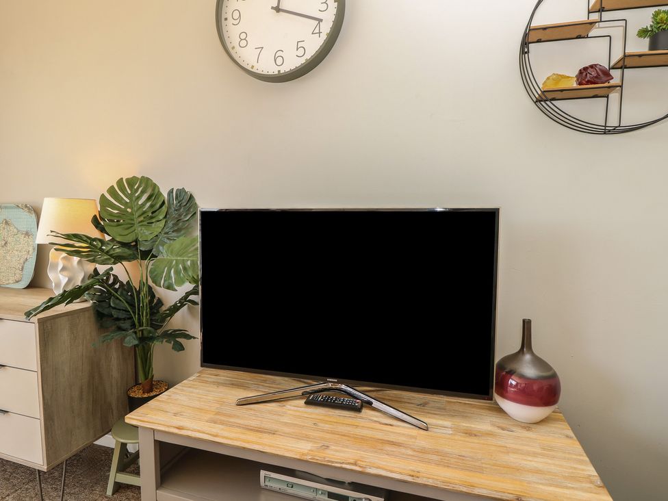 A living room with a TV on a cabinet at 57 Cliff End in Freshwater