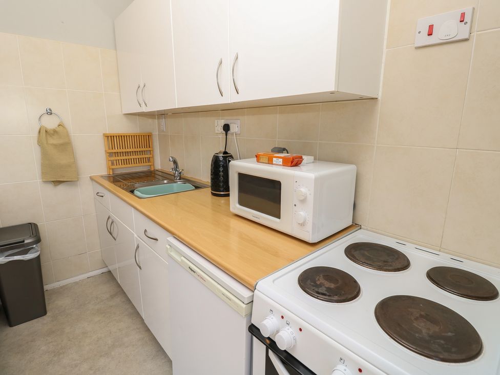 A kitchen with a sink and appliances at 57 Cliff End in Freshwater