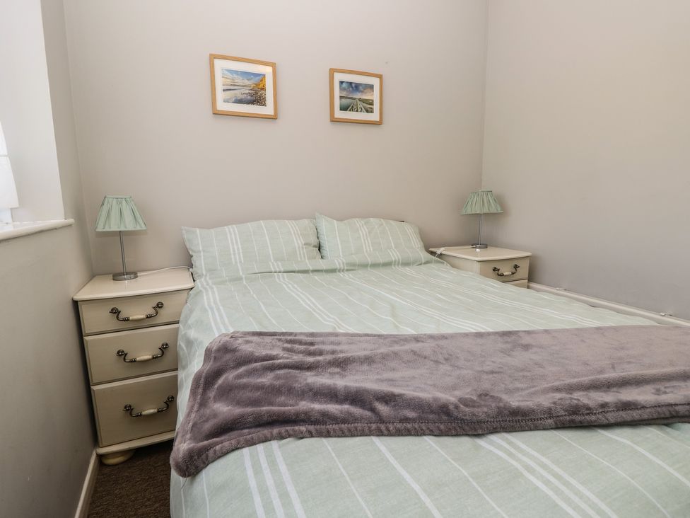 A bedroom with a bed and bedside tables at 57 Cliff End in Freshwater