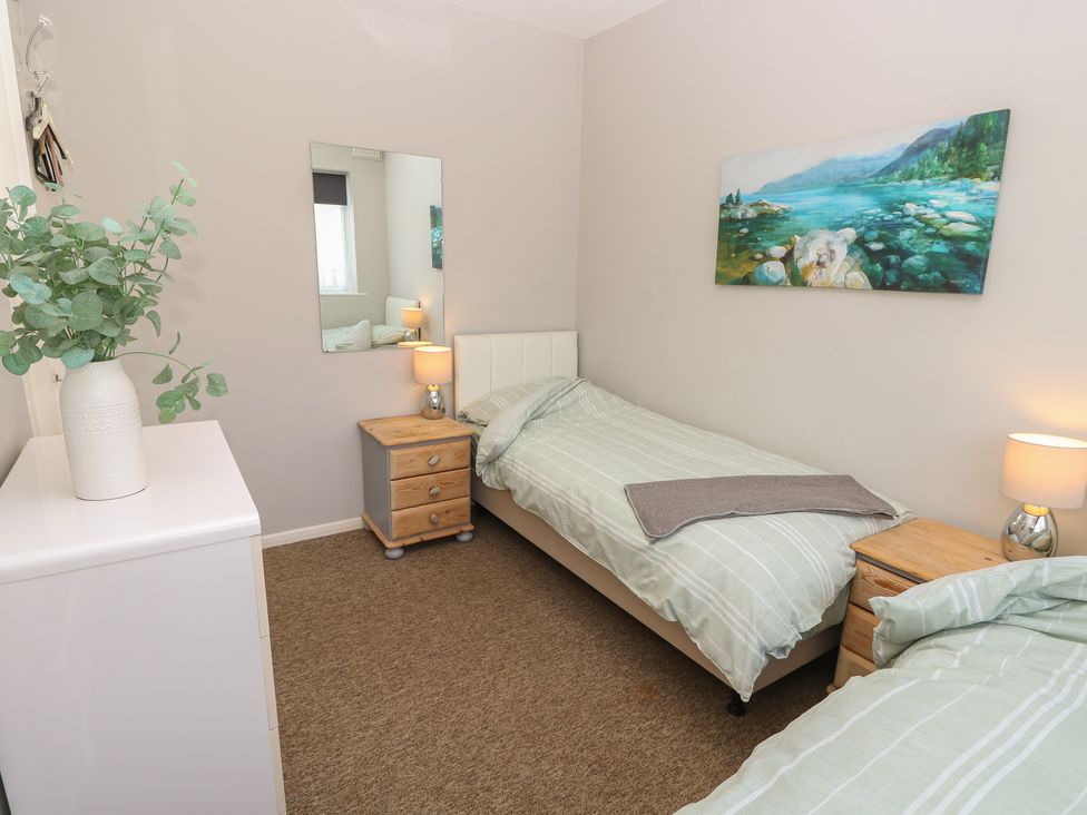 A bedroom with two beds and a chest of drawers at 57 Cliff End in Freshwater