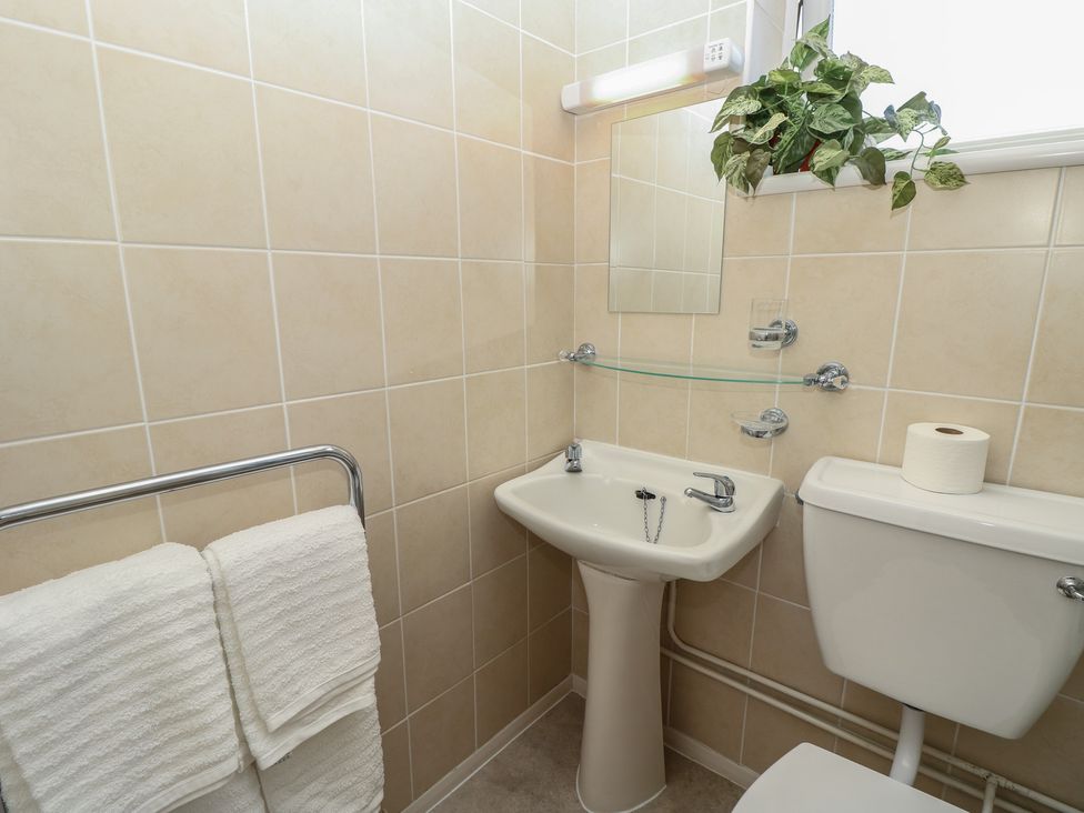 A bathroom featuring a sink and toilet at 57 Cliff End in Freshwater