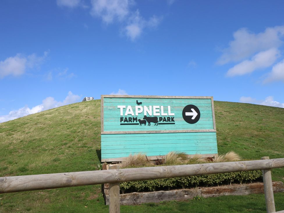 A sign for Tapnell Farm Park with direction at 57 Cliff End in Freshwater