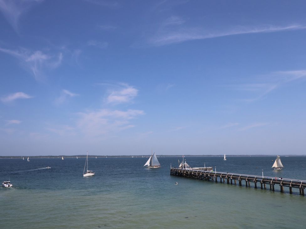 A view of boats sailing near a pier at 57 Cliff End in Freshwater