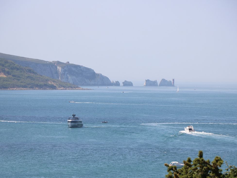 A view of the sea with boats and cliffs at 57 Cliff End Freshwater