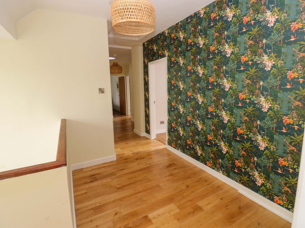 A hallway with patterned wallpaper and wooden flooring at 331 Coniscliffe Road in Darlington