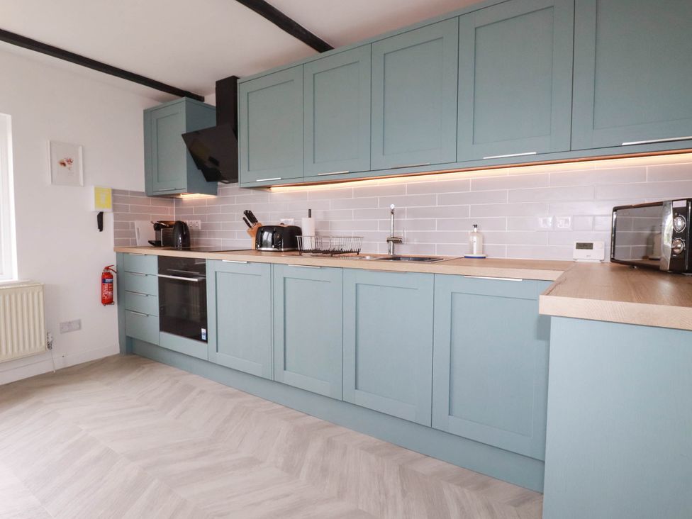 A kitchen with cabinets and appliances at Little House in Wadebridge