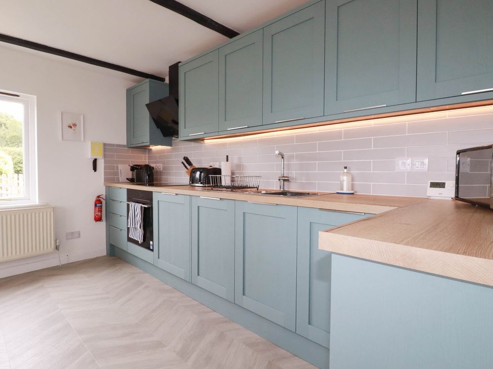 A kitchen with cabinets, sink, and appliances at Little House in Wadebridge