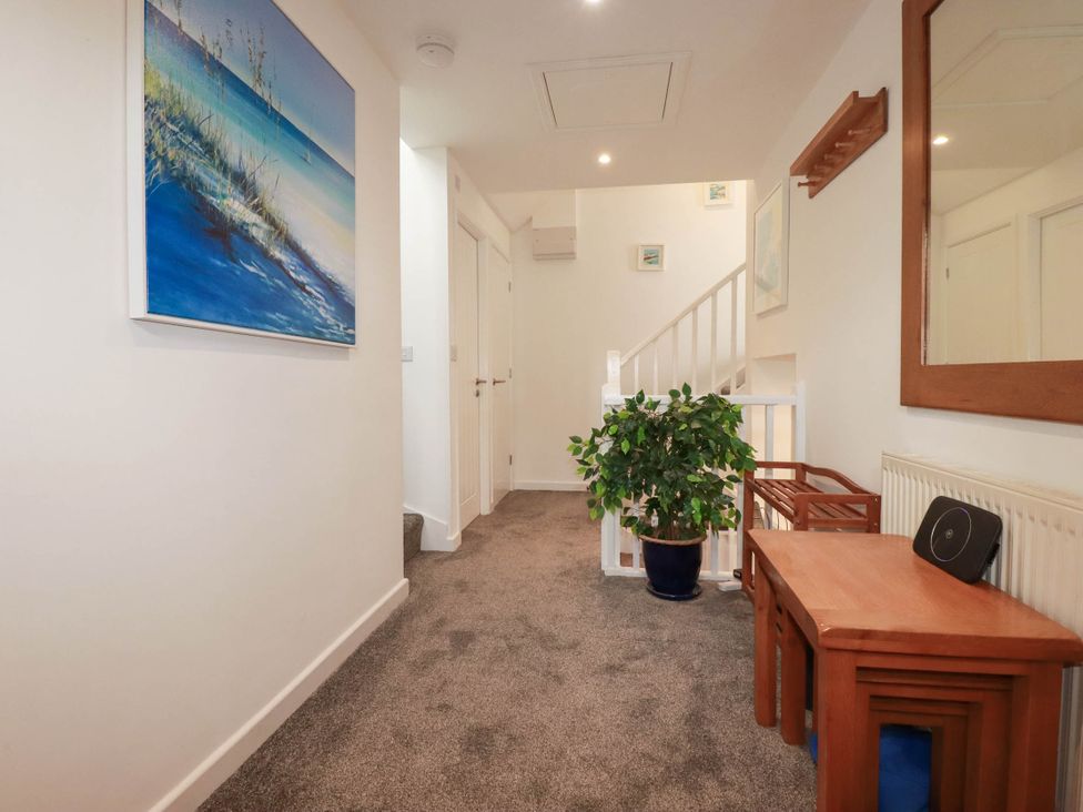 A hallway with a painting and a plant at Little House in Wadebridge