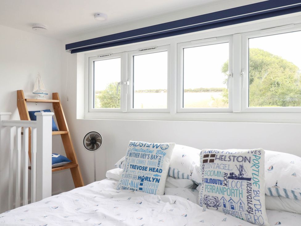 A bedroom with a bed and window at Little House in Wadebridge