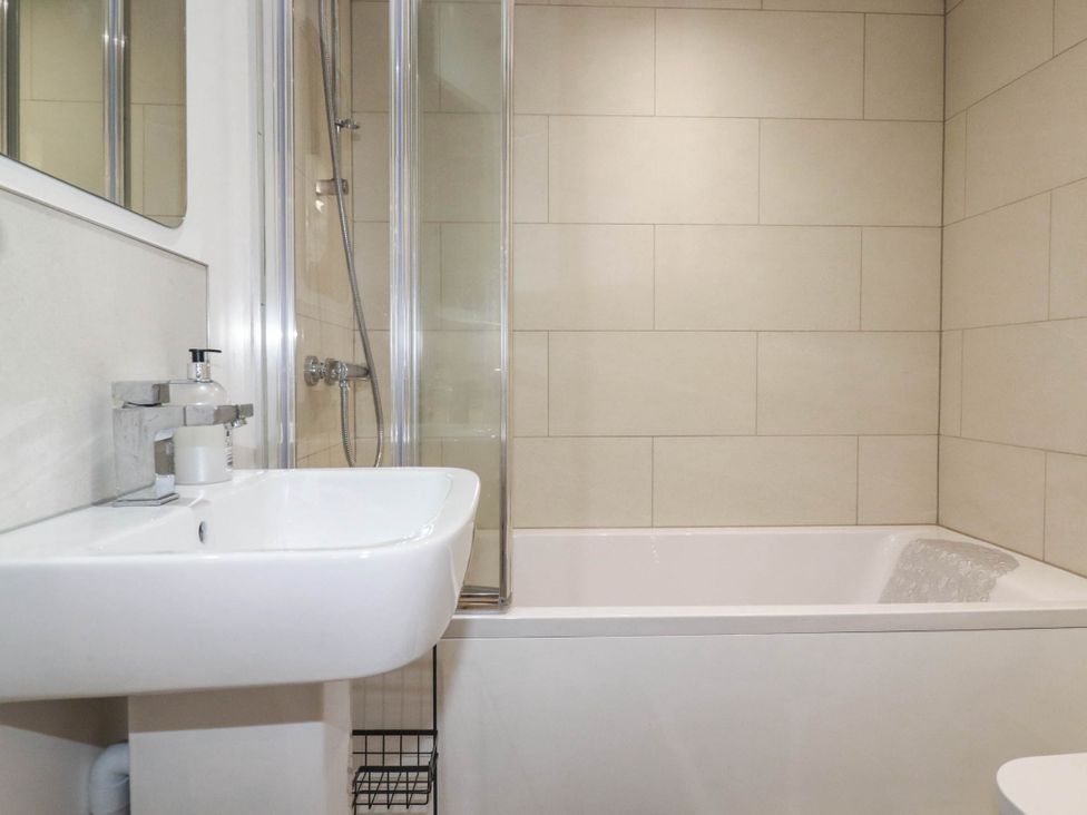 A bathroom with a bathtub, shower, and sink at Little House in Wadebridge