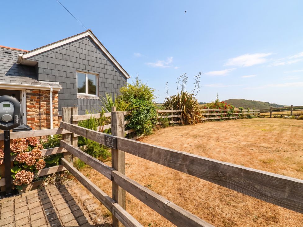 An outdoor view of a house with flowers and a fence at Little House in Wadebridge