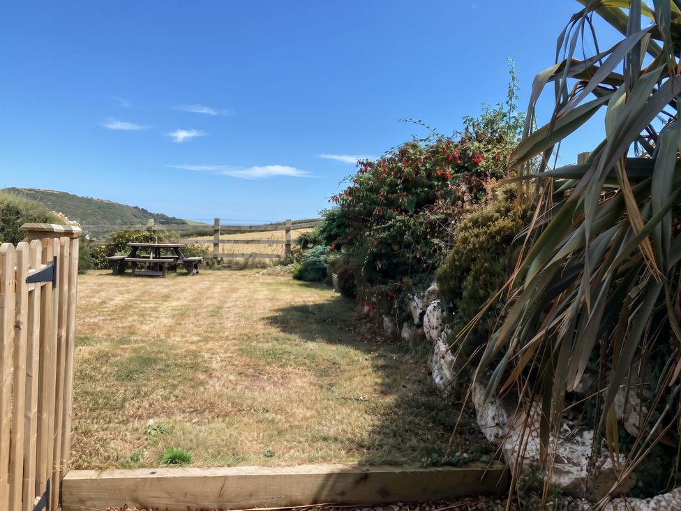 A garden with a picnic table and bushes at Little House in Wadebridge