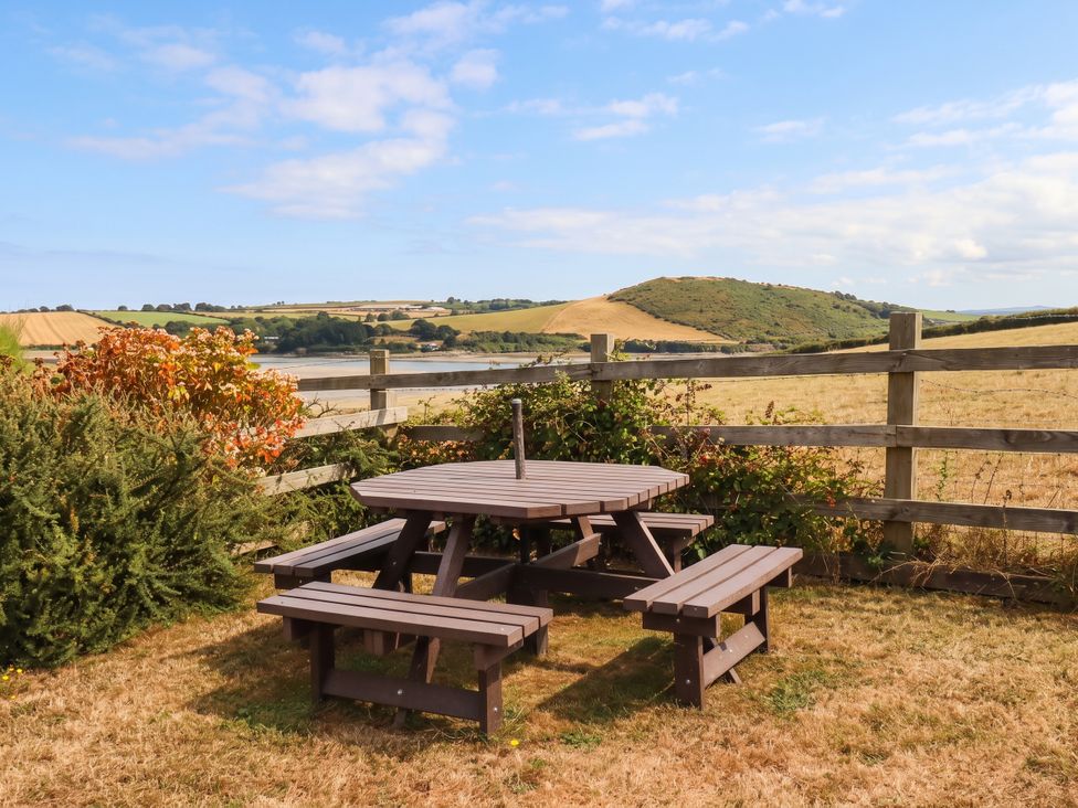 A picnic table with benches in an outdoor area at Little House in Wadebridge