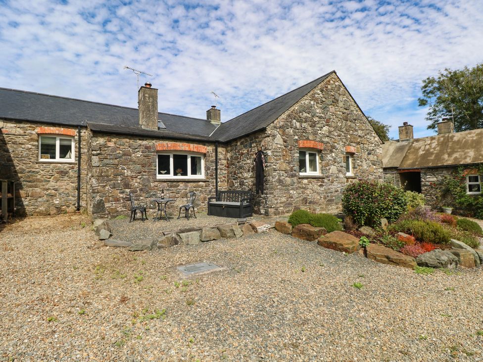 An outdoor area with stone walls and seating space at The Old Dairy near Solva