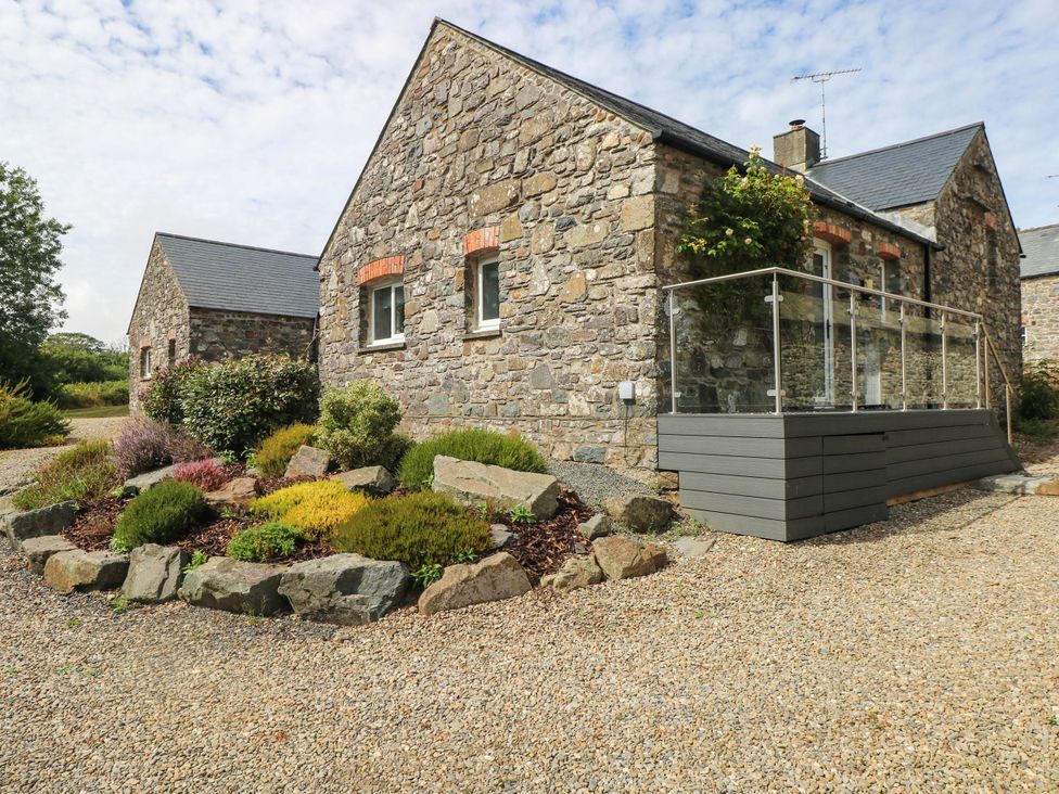 An outdoor view of stone houses and a landscaped garden at The Old Dairy near Solva