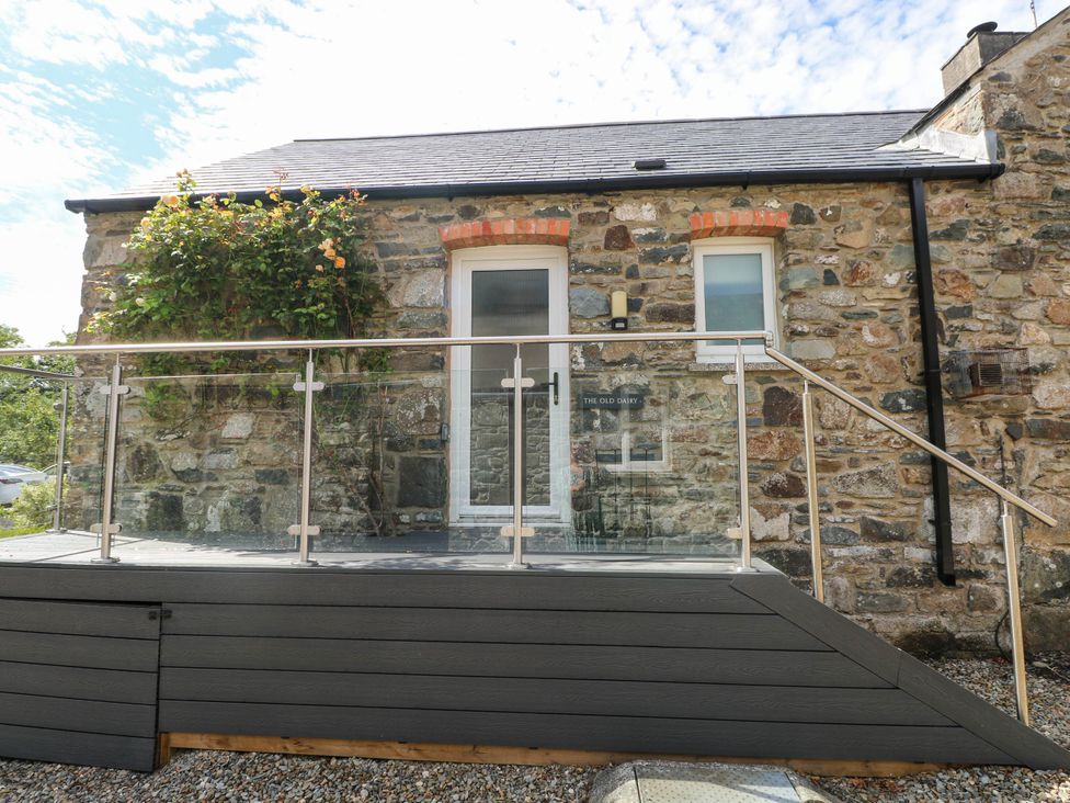 An entrance with a glass railing and stone wall at The Old Dairy near Solva